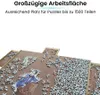 A puzzle board with many puzzle pieces scattered across it, and a partially completed image of a person in blue clothing. Produktbild-Vorschau