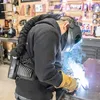 A person is welding in a workshop. Produktbild-Vorschau