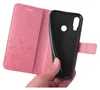 A hand holding a pink floral flip phone case, revealing the black inner shell. Produktbild-Vorschau