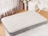 An inflatable mattress is shown on a rug in a room with sheer curtains and furniture in the background. Produktbild-Vorschau