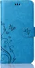 A blue flip case for a mobile phone with a floral and butterfly embossed pattern. Produktbild-Vorschau