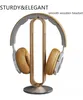 A pair of headphones rests on a wooden stand. Produktbild-Vorschau
