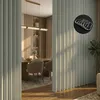 A dining room with a partition and a glimpse of a table and chairs. Anteprima dell’immagine prodotto