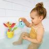 A toddler is playing with a bath toy in a bathtub. Podgląd zdjęcia produktu