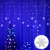 A decorated Christmas tree and a lamp are illuminated by blue snowflake string lights against a blue curtain background. Náhled obrázku produktu