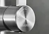 A close-up of a brushed stainless steel faucet handle with temperature indicators. Produktbild-Vorschau