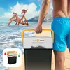A person carrying a cooler on a beach with a woman relaxing in the background. Anteprima dell’immagine prodotto