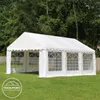 A white party tent is set up on a green lawn with trees in the background. Voir les images du produit