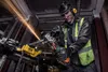 A construction worker is using an angle grinder to cut metal, with sparks flying. Voir les images du produit