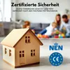 A wooden toy house is in the foreground, with a blurred family playing in the background. Certification logos are visible. Produktbild-Vorschau