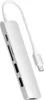 A white USB-C hub with multiple ports and a white cable connected to a USB-C connector. Voir les images du produit