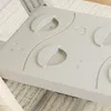 A close-up view of a gray plastic play structure with circular indentations and curved raised elements. Produktbild-Vorschau