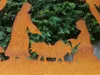 A nativity scene made of rusted metal, set against a backdrop of green foliage. Anteprima dell’immagine prodotto