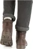 A close-up view of a person's legs wearing brown leather boots and grey cuffed jeans. Produktbild-Vorschau