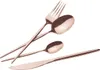 A set of rose gold cutlery, including a fork, a large spoon, a small spoon, and a knife, arranged diagonally on a white background. Anteprima dell’immagine prodotto