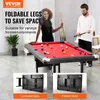 A couple playing billiards in a room, with a demonstration of the table's foldable legs. Produktbild-Vorschau
