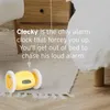 A yellow alarm clock with wheels is on the floor next to a bed and a wooden nightstand. Text overlays describe the product's features. Podgląd zdjęcia produktu