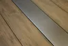 A close-up view of a wooden surface with a metallic strip running through it. Produktbild-Vorschau