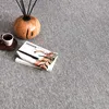 A coffee cup, a book, and a diffuser are placed on a gray carpet. Produktbild-Vorschau