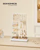 A white jewelry stand filled with various necklaces, earrings, and watches, placed on a light-colored surface. Produktbild-Vorschau
