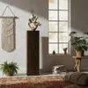 A living room scene with a wooden column, macrame wall hanging, plants, and a rug. Produktbild-Vorschau