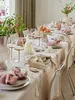 A dining table set for a meal with plates, cutlery, glasses, napkins, and a centerpiece. Voir les images du produit