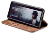 A smartphone in a brown flip case is displayed against a white background, showing a movie poster on its screen. Produktbild-Vorschau