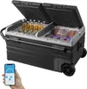 A hand holds a smartphone displaying a temperature control app next to a large, dual-compartment portable refrigerator with its lids open, showing bottles of beverage in one compartment and packaged food in the other. The refrigerator has wheels and a hand Náhled obrázku produktu