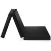 A black folding mattress is shown in a semi-folded position, with one section flat on the ground and the other two sections angled upwards, forming an 'A' shape. Voir les images du produit