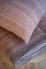 A close-up of a folded blanket and a pillow, both with a textured pattern in shades of brown and white. Náhled obrázku produktu