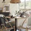 A dining set with a round wooden table and chairs in a bright, airy room with a window view. Podgląd zdjęcia produktu