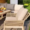 An outdoor patio setting with a sectional sofa and armchair, a coffee table with fruit, and a garden in the background. Náhľad obrázku produktu