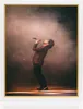 A man singing on stage with smoke and stage lighting. Produktbild-Vorschau