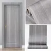 A collage showing a door covered in wood-effect wallpaper, a roll of the wallpaper, and a close-up of the wallpaper texture. Náhľad obrázku produktu