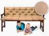 Two young children are lying under a wooden bench with a sand-colored cushion. Produktbild-Vorschau