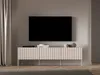 A modern TV lowboard with fluted fronts is shown against a neutral wall, with a television mounted above it. Produktbild-Vorschau