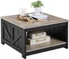 A square coffee table with a wood-look top and black base, decorated with two storage boxes and a plant. Produktbild-Vorschau