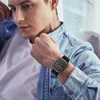 A man wearing a denim shirt and a watch. Produktbild-Vorschau
