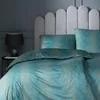 A bed with teal and gold patterned bedding, a headboard, and a bedside table with a lamp. Produktbild-Vorschau