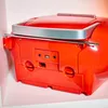 The back of a red boombox is shown, resting on a light pink surface. Produktbild-Vorschau