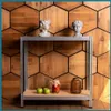 A metal shelving unit with decorative busts on the top shelf and jars and apples on the bottom shelf, set against a hexagonal wooden wall. Podgląd zdjęcia produktu
