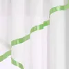 A close-up view of a white sheer curtain with a green satin ribbon trim. Produktbild-Vorschau