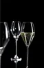 Three champagne flutes are arranged on a black background. One flute in the foreground is filled with champagne and bubbles, while the other two are empty and slightly out of focus. Anteprima dell’immagine prodotto