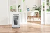 A white and gray paper shredder is shown in a clean, modern office setting. Voir les images du produit