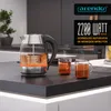 A glass and stainless steel electric kettle is shown on a dark countertop, with steam rising and two glasses of tea nearby. Promotional text is overlaid on the right side of the image. Produktbild-Vorschau