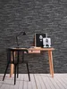 A desk with a chair, lamp, and artwork against a stone-patterned wall. Náhľad obrázku produktu