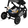 A close-up view of the lower part of a stroller, showing the storage basket with a teddy bear and baby items inside. Produktbild-Vorschau