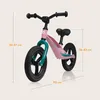 A pink balance bike with teal accents, shown with measurement lines and text indicating dimensions. Produktbild-Vorschau
