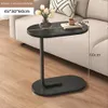 Schwarzer C-förmiger Beistelltisch mit ovaler Platte und Sockel, neben einem hellen Sofa platziert, mit Maßen Voir les images du produit