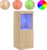 A tall, narrow cabinet with a glass-fronted section illuminated by blue LED lights, set against a white background. Above the cabinet are three circular swatches showing different colored lights (beige, red, green) and a color wheel. Produktbild-Vorschau